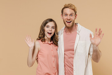 Young cool surprised parent man have fun with cute child teen girl in casual pastel clothes. Daddy little kid daughter waving hand isolated on beige color background. Father's Day Love family concept.