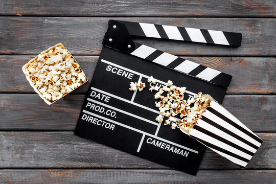 Film reel with popcorn and clapperboard. Cinema concept