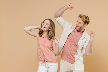 Young happy parent man have fun with child teen girl in casual pastel clothes Daddy little kid daughter dancing on birthday party isolated on beige background studio. Father's Day Love family concept