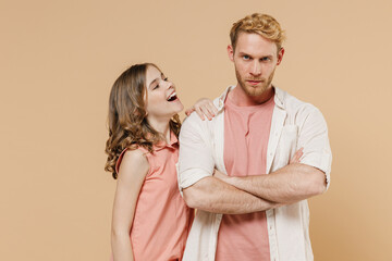 Young caucasian offended frowning parent man with smiling child teen girl wearvcasual pastel clothes. Daddy little kid daughter hold hands crossed folded isolated on beige background studio portrait.