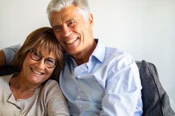 Close up smiling older couple sitting on couch