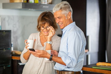smiling older couple looking at mobile phone