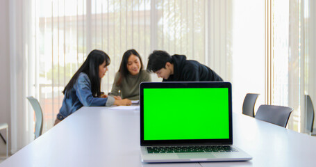 Asian students use notebook and tablet computers on green screen to work