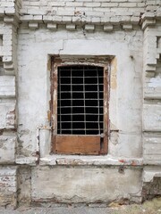Fototapeta na wymiar An old barred window in an abandoned house