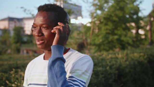 Black young man listens to music with headphones