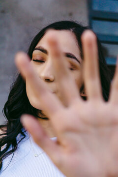 Teen showing stop gesture with hand in daytime
