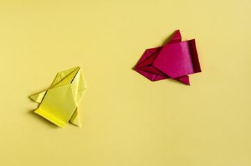 Concept paper cars in yellow and red on a colored background close-up. Origami colored paper racing cars	