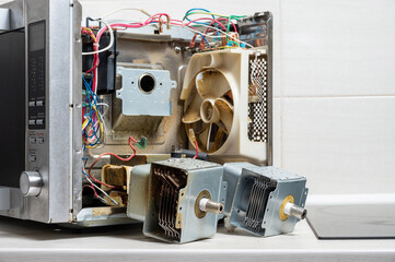 New and old magnetrons next to the disassembled microwave