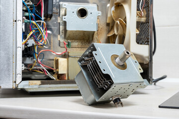 Old magnetron next to the disassembled microwave