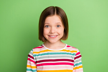 Photo of impressed nice small girl wear colorful shirt isolated on green color background