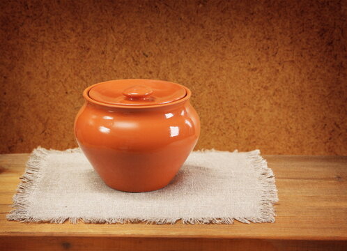 Clay pot for cooking and napkin on wooden table