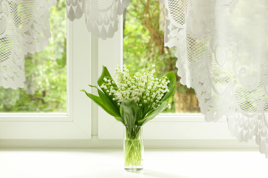 Bouquet of lily of the valley on the windowsill