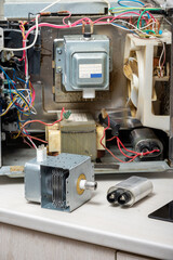 New magnetron and capacitor next to the disassembled microwave