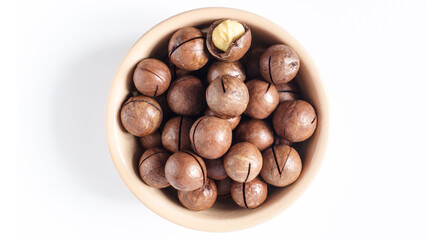 Full bowl of macadamia nuts, macadamia nuts in a cup on a light background