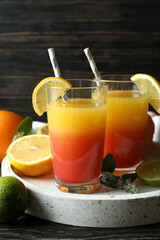 Tray with Tequila Sunrise cocktails on wooden table