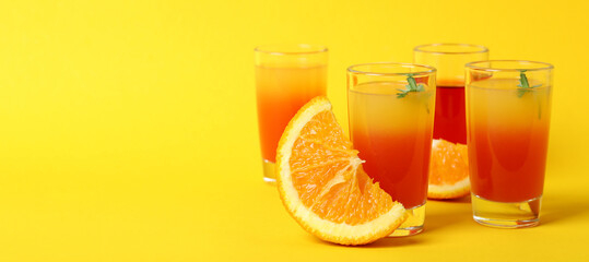 Tequila sunrise cocktails and ingredients on yellow background