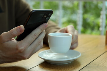 Man drink coffee and holds phone, close up