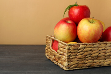 Basket with red apples on dark wooden table