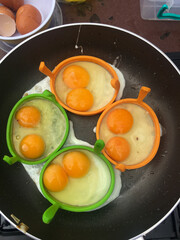 Four eggs with unusual two yolks per egg in a frying pan 