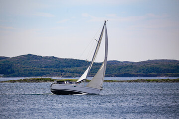 Obraz premium Sailboat with wind in the sails along the Norwegian coast,Helgeland,Nordland county,Norway,scandinavia,Europe