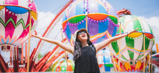a beautiful asian girl enjoy her holiday at amusement park on a sunny day, nice clear sky, women wearing sunglasses, smiling girl, happy vacation - obrazy, fototapety, plakaty