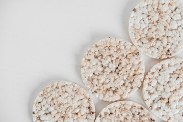 Round diet crispbreads on a white background. Round shaped cereal bread, healthy food without yeast. Top view. Copy, empty space for text