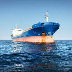 Large blue cargo ship anchored in Strait of Gibraltar. A view from the yacht, close-up. Summer...