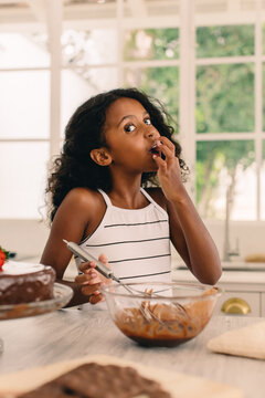 Young Girl Licking Batter From Bowl