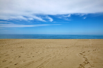 Fototapeta na wymiar White clouds, blue sea and yellow sandy beach