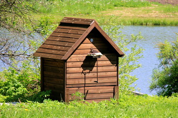 Wooden smokehouse in the farm by the pond. Wooden smokehouse in the countryside. Homemade meat smoking