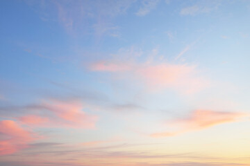 Clear blue sky. glowing pink, golden cirrus and cumulus clouds after storm, soft sunlight. Sunset...