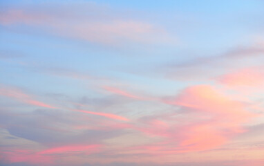 Clear blue sky. glowing pink, golden cirrus and cumulus clouds after storm, soft sunlight. Sunset...