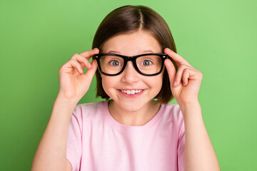 Photo of young excited girl happy positive smile wear glasses vision ophtalmology isolated over green color background