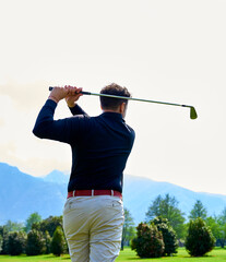 Golfer on the professional golf course. Golfer with golf club hitting the ball for the perfect shot.