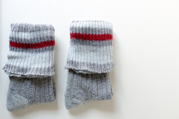 old wool socks folded and isolated on an old white paper background