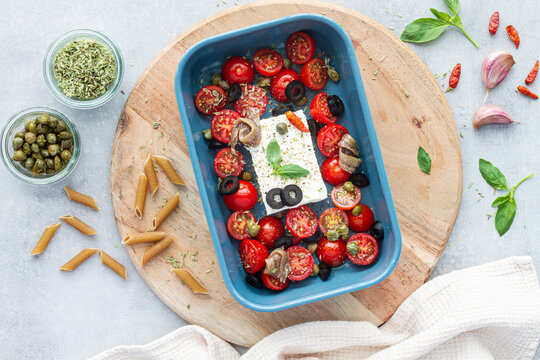 Baked cherry tomato halves with feta cheese in baking pan
