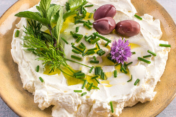 close-up of homemade labneh cheese with herbs and olives