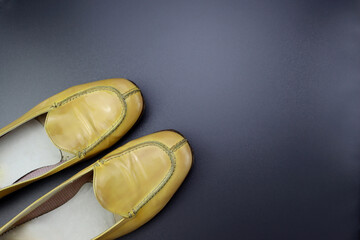 Women's patent leather shoes. Yellow loafers on a gray background. 
