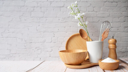 Kitchen accessories in white wooden table and white background and white tableware with salt in wooden bowl and tree. Kitchen minimal cooking time in holiday concept..