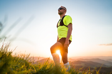 Portrait of Active mountain trail runner dressed bright t-shirt with backpack and sport sunglasses...