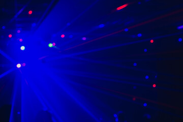 Blurry background with laser blue lights of a disco, dance floor