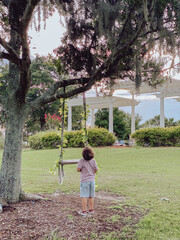 Boy playing on a swing in a park in orlando Florida at a golf course in lake nona 