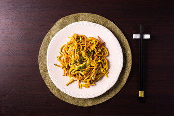 Asian vegetarian food udon noodles on plate with chopsticks on the table. horizontal top view