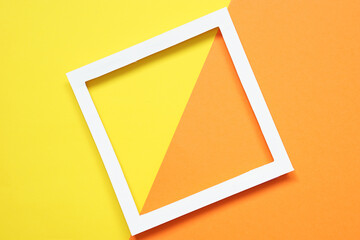 white paper frame on yellow and orange background, top view, flat lay.