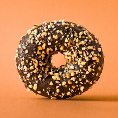  Chocolate donut with almonds on orange background.