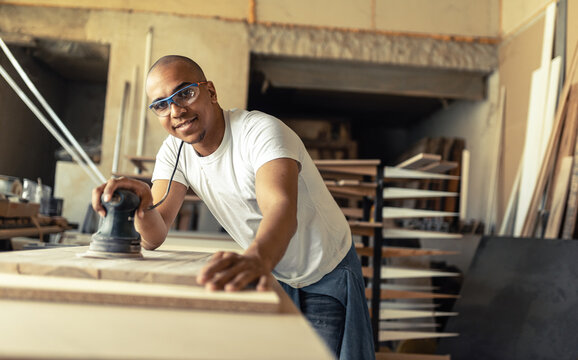 Portrait of young black man carpenter in his workshop.	
