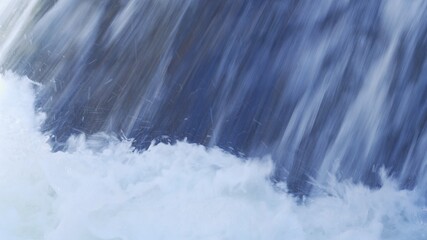 Texture of water pouring at high speed, close-up. Falling drops of water, blurred motion.