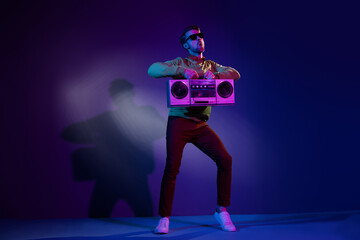 Full length body size photo man in sunglass dancing listening music with retro tape recorder isolated on violet color background