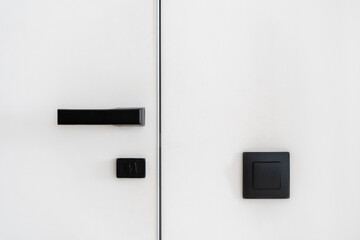 Black matt doorhandle and light switch in room