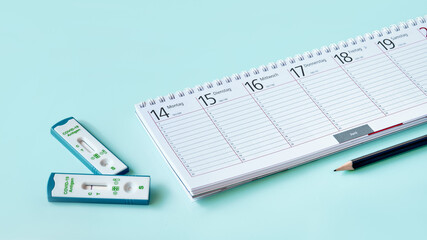 Banner with shnelltest, weekly planner, calendar, pencil on mint blue table. Schnelltest means rapid corona test in German language. Express test is fast way to test for acute coronavirus infection